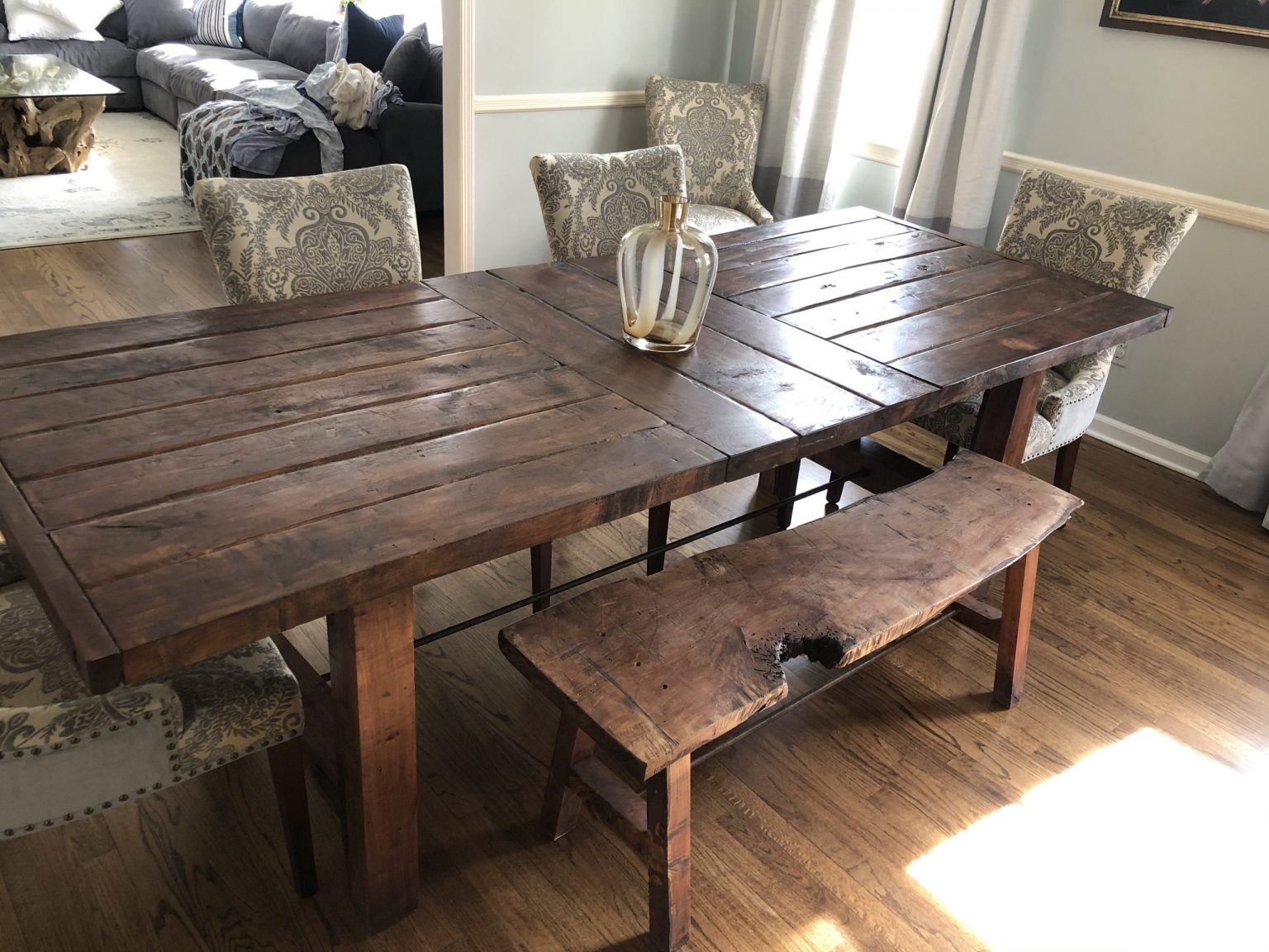 A handmade solid-wood farmhouse dining table by Mad Cedar Woodworks